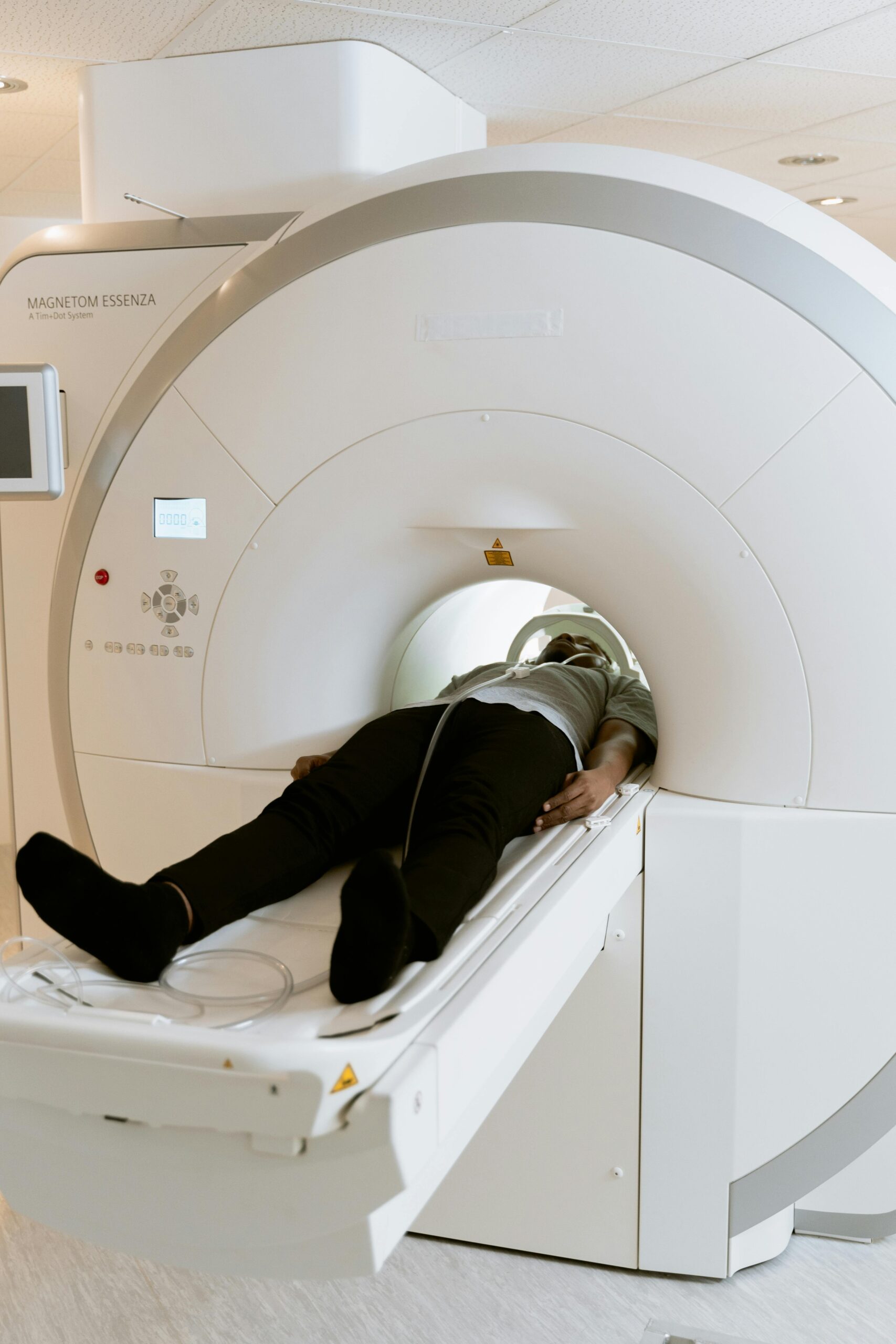 A person lying in an MRI machine during a medical screening in a healthcare facility.